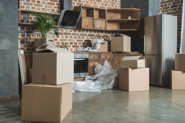 cardboard boxes in empty kitchen during relocation - Fotografie, Obrázek