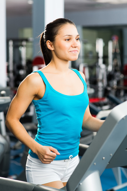 Young woman running on a treadmill - Фото, изображение