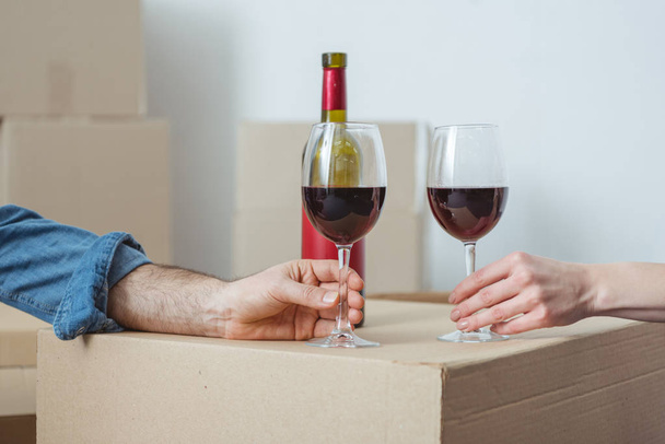partial view of couple holding glasses of wine and celebrating relocation - Photo, Image