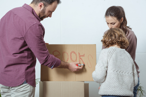 familia con un niño cantando caja de cartón mientras se muda a un nuevo hogar
 - Foto, Imagen