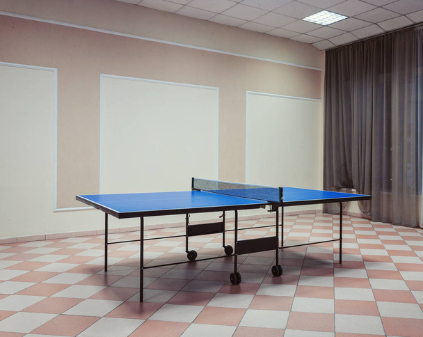 Foto de estilo antigo. Mesa de ténis de pingue-pongue com pás no chão
 - Foto, Imagem