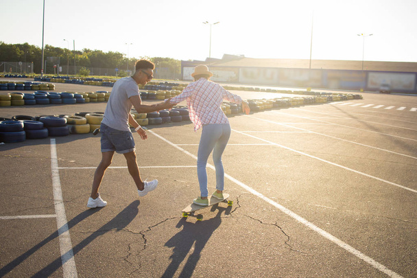 Happy young couple with skateboard, concept of happiness, love and youth. - Фото, зображення