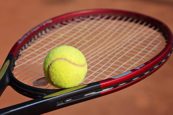 Close-up van tennisracket en balletjes op de klei-Tennisbaan - Foto, afbeelding