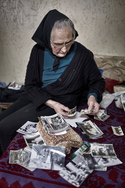 Old woman looking at photos - Foto, imagen