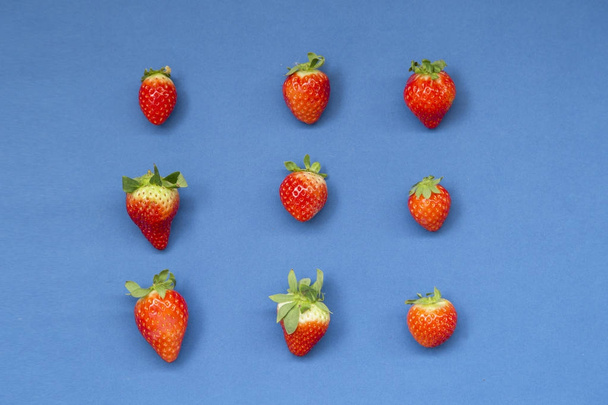 Top view of colorful fruit pattern of fresh strawberries on blue background - Photo, image