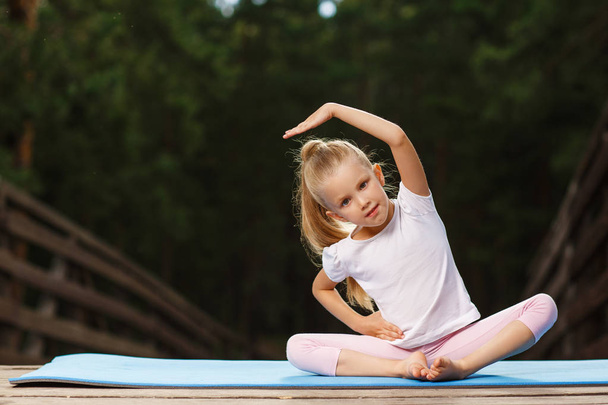 Little girl doing fitness outdoor - Zdjęcie, obraz