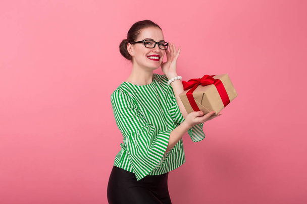 Szczęśliwy piękną, młodą kobietę w stylowe okulary przytrzymanie pudełko  - Zdjęcie, obraz