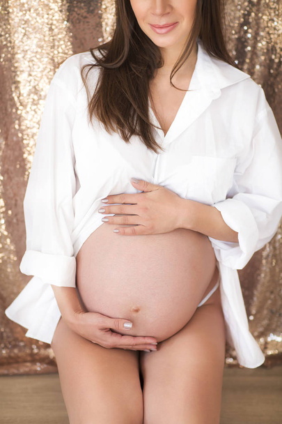 Kobieta w ciąży, w pomieszczeniu siedzi na podłodze - Zdjęcie, obraz