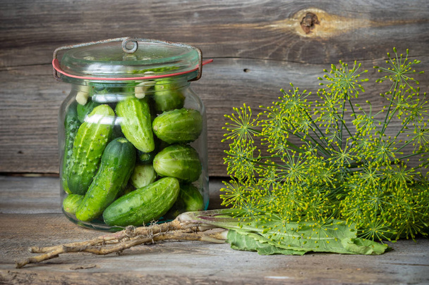 Jars of pickled marinated cucumbers on rustic table  - Foto, Imagem