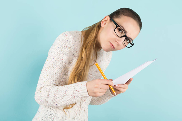 Pretty girl in stylish eyeglasses making notes on paper - Zdjęcie, obraz