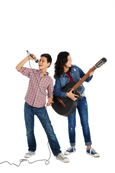 Boy singing in microphone and his sister is playing guitar - Φωτογραφία, εικόνα