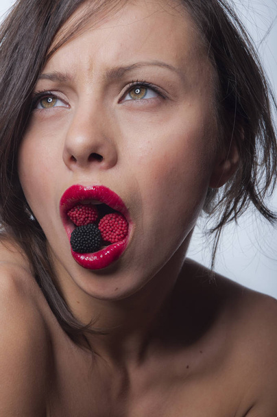 Menina com um doce na boca
  - Foto, Imagem