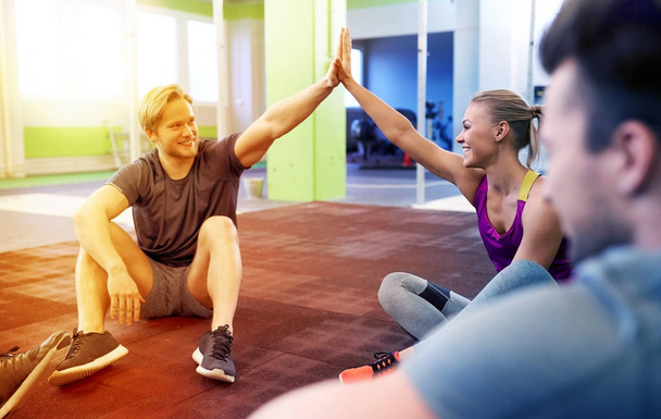 group of happy friends making high five in gym - Foto, afbeelding
