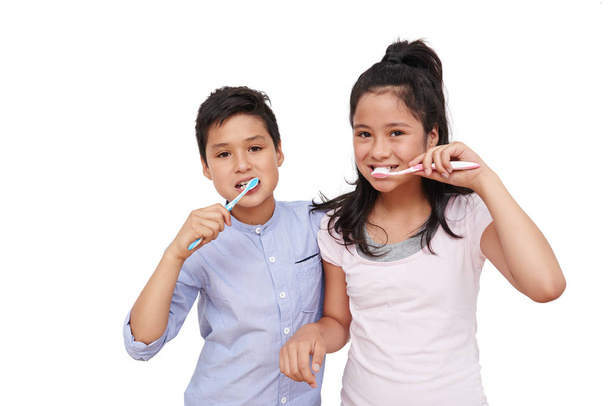 Irmão e irmã escovando os dentes juntos, isolados em branco
 - Foto, Imagem