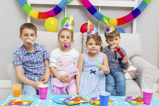 Happy group of children celebrating friends birthday. Kids party. - 写真・画像