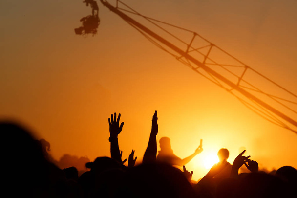 χέρια χαρούμενων ανθρώπων πλήθος που διασκεδάζουν στη σκηνή στο καλοκαιρινό live rock fest - Φωτογραφία, εικόνα