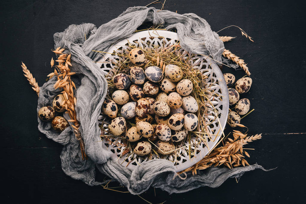Quail eggs in a metal plate. On a wooden background. Top view. Copy space. - Fotografie, Obrázek