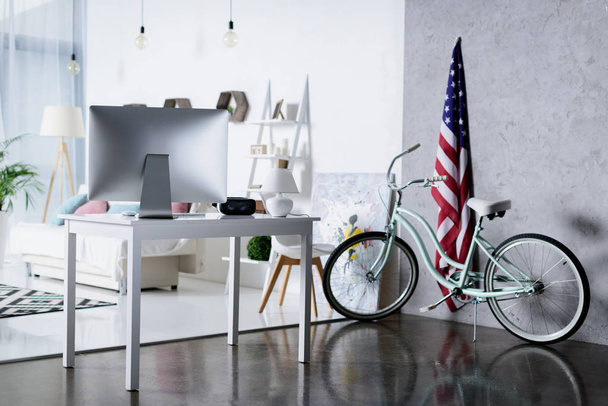 silver computer on table and bicycle near wall in room - Foto, imagen