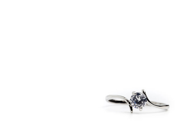 Fake diamond ring placed on a white background. The concept of love or marriage. Copy space can be used to write articles about Valentine's Day. - Photo, Image