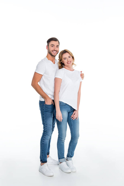 couple in casual clothing hugging and looking at camera, isolated on white - Photo, Image