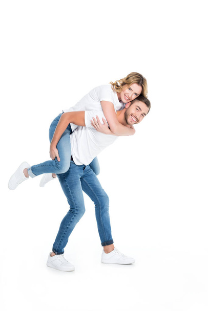 handsome man piggybacking his smiling girlfriend, isolated on white - Foto, Imagem