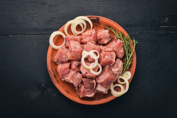 Raw meat is cooked for shish kebab on a wooden background. On the plate Top view. Free space for text. - Foto, Imagen