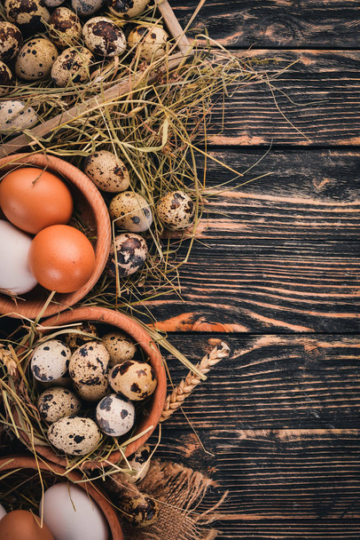A set of chicken and quail eggs. On a wooden background. Top view. Copy space. - Foto, Imagem