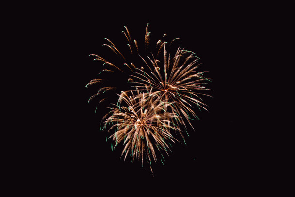 Πολύχρωμο πυροτέχνημα σε ουρανό τη νύχτα. Πυροτεχνήματα το νέο έτους γιορτή. Αφηρημένη πυροτέχνημα που απομονώνονται σε μαύρο φόντο με ελεύθερο χώρο για το κείμενο - Φωτογραφία, εικόνα