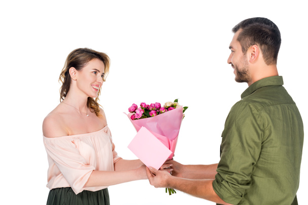 side view of man presenting bouquet of flowers and postcard to wife isolated on white - Fotografie, Obrázek