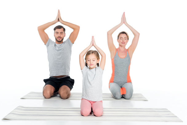 athletic family practicing yoga on mats together isolated on white - Zdjęcie, obraz