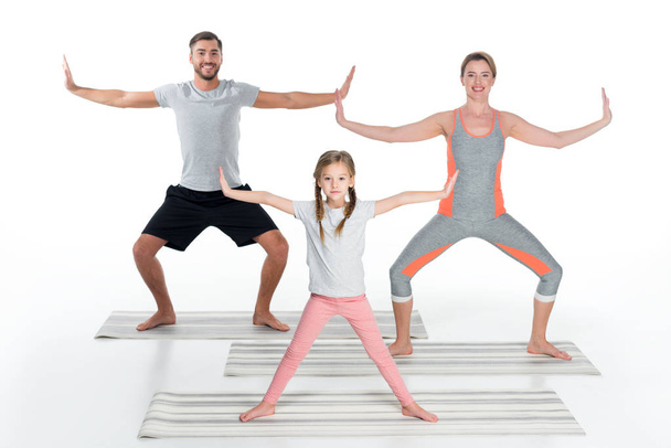 familia atlética practicando yoga sobre esteras juntas aisladas sobre blanco
 - Foto, imagen