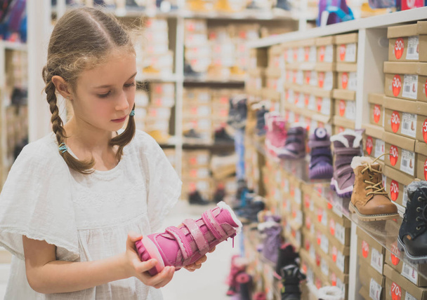 Little girl choosing winter shoes in the mall. - Fotoğraf, Görsel