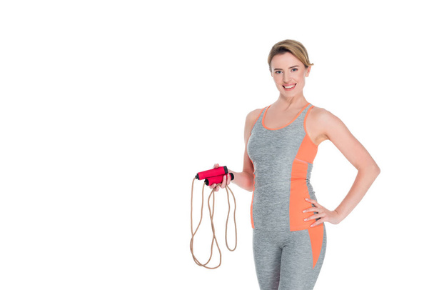 portrait of smiling sportswoman with jumping rope isolated on white - Foto, Imagen