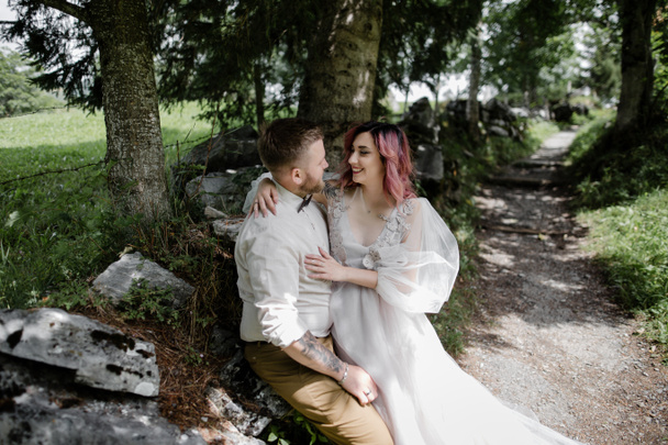 happy young bride and groom hugging and smiling each other in beautiful mountain valley, Alps - Photo, Image