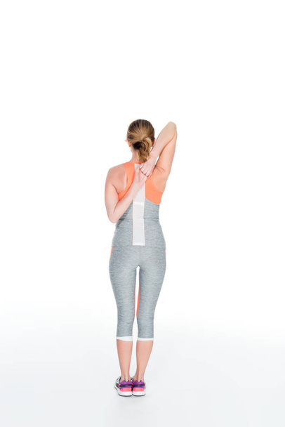 back view of sportswoman stretching before training isolated on white - Valokuva, kuva