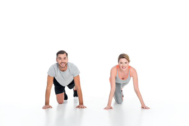 smiling sportive couple exercising together isolated on white - Photo, Image