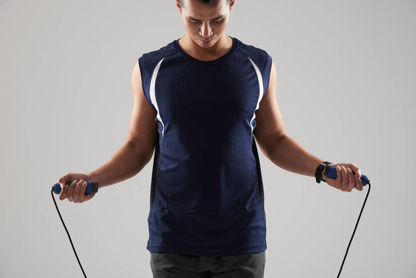 Sporter traint met springtouw, geïsoleerd op lichtgrijs - Foto, afbeelding