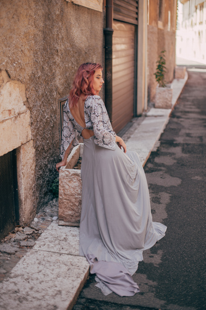 attractive elegant girl with pink hair in glamorous dress walking in Verona - Foto, Imagem