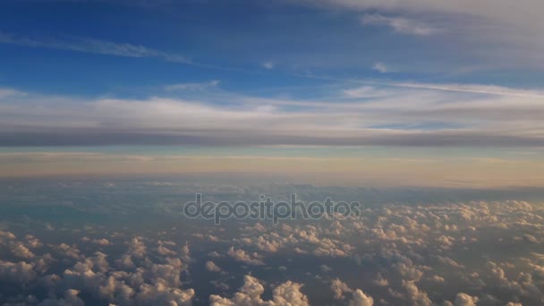 Beautiful aerial view of cloudscape from sky level, showing heaven-like scenery of clouds moving, both above and below in late afternoon pale pink lights from the right, and blue sky color on top - Footage, Video