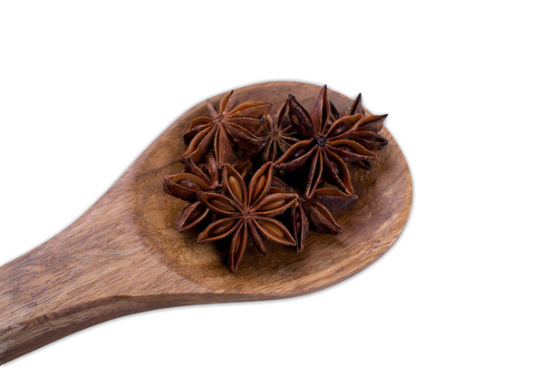Γλυκάνισο star σχετικά με ξύλινο κουτάλι που απομονώνονται σε λευκό φόντο - Φωτογραφία, εικόνα
