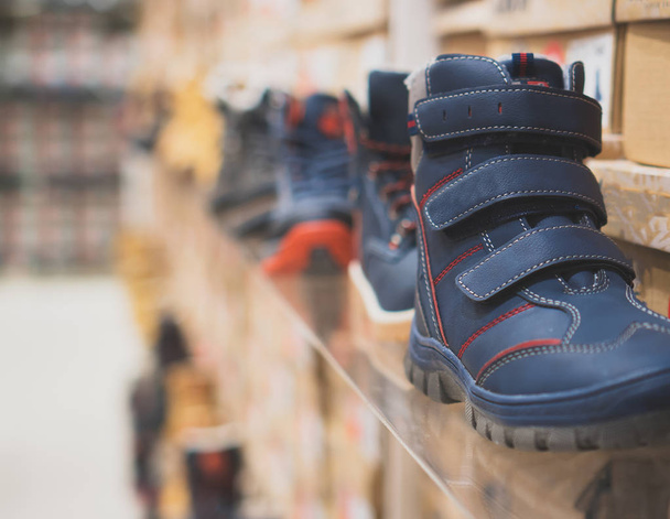 Collection of different winter kids shoes in shop. - Photo, Image