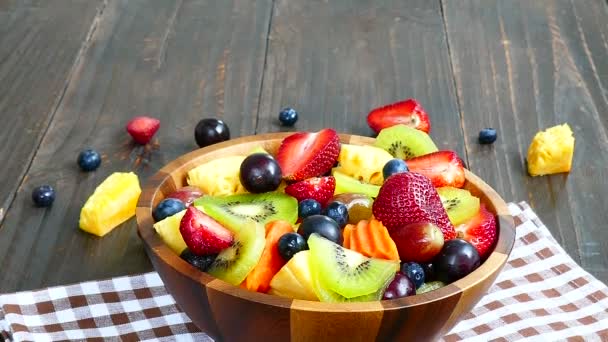 різноманітні стиглі фрукти та ягоди в дерев'яній мисці на сільському столі
  - Кадри, відео