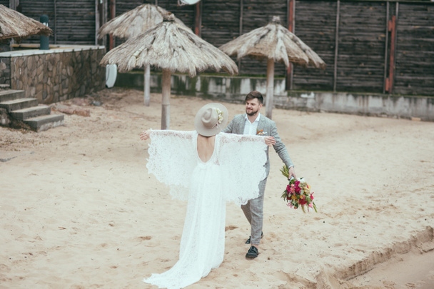 beautiful happy bridal couple in bohemian style on beach - Foto, immagini