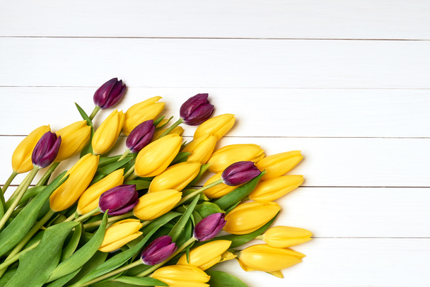 Gele tulpen boeket op witte houten achtergrond. Boeket. Kopie ruimte, bovenaanzicht. - Foto, afbeelding