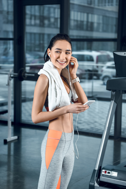 young sporty woman listening music with earphones at gym - Photo, Image