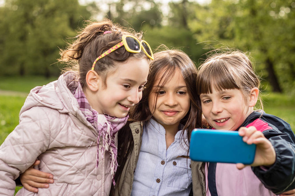 Photo of girls making selfie in green park - Valokuva, kuva