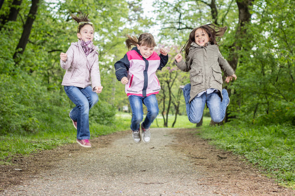 Foto de tres chicas saltando en el parque
 - Foto, imagen