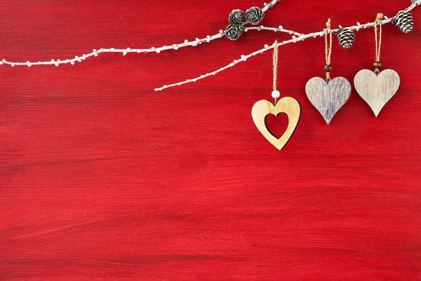 Fundo vermelho com três corações de madeira. Dia dos Namorados fundo. Espaço de cópia, vista superior
 - Foto, Imagem