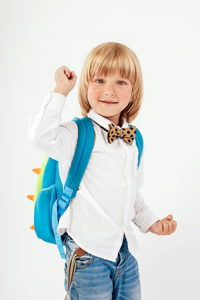 学校、子供、リュックサック。小さな男の子は蝶ネクタイに身を包んだ。陽気な大きなバックパックと小さな子供の笑顔します。カメラを見ています。学校のコンセプトです。学校に戻る - 写真・画像