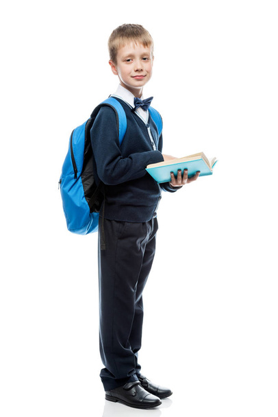 schoolboy with a book and a backpack in the studio on a white ba - Foto, imagen